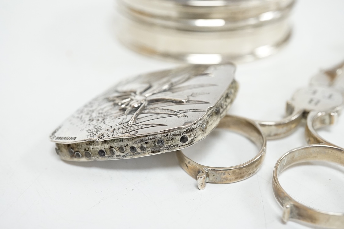 A George V silver and tortoiseshell pique mounted circular trinket box, Collett & Anderson, London, 1922, diameter 77mm, together with a pair of 18th century silver sugar nips and a sterling mounted pin cushion, decorate